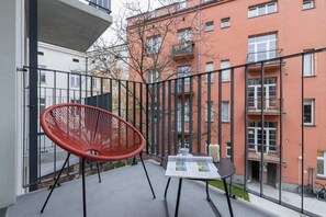 Spacious balcony with outdoor furniture. 