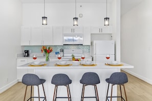 Fully equipped kitchen with countertop dining area with 4 bar stools