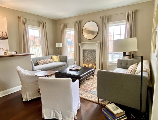 Apt1_LR_Living_Faux Fireplace_Leather Ottoman_West Elm couches_