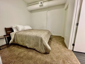 Master bedroom with attached bathroom and queen bed in 303