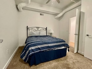 Bedroom with queen bed, large walk-in closet and in-room washer and dryer.