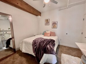Second bedroom with queen bed and vanity.
