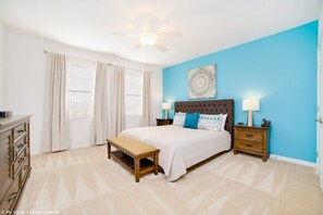 Cozy master bedroom with vibrant decor and natural light.