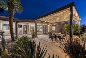 Large covered patio with dining table & grill