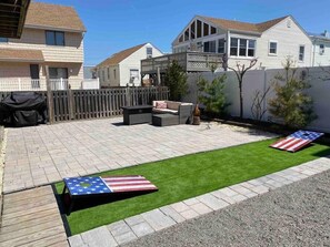 Backyard patio: Fire pit, cornhole, grill