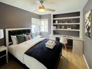  This bedroom comes with a queen-sized bed, workplace area, & 2 bed-side tables