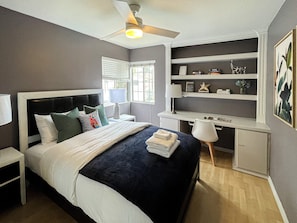  This bedroom comes with a queen-sized bed, workplace area, & 2 bed-side tables