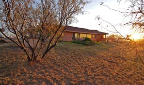 view of the house Arizona room with the large windows) from the back field
