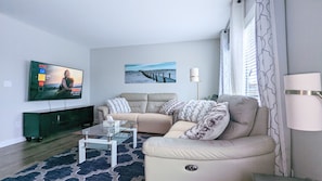 Main floor Sitting room with recliner sofa & 65" Smart TV