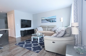 Main floor Sitting room with recliner sofa & 65" Smart TV