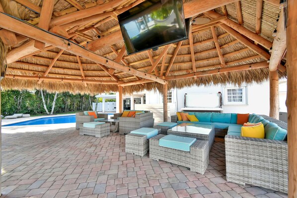 Heated Pool, jacuzzi, Tiki Huts and outdoor kitchen with plenty of seating options in this wonderfully social private yard