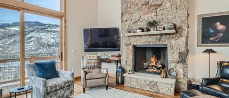Open plan living room with gas fireplace and amazing mountain views.