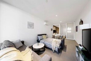 A spacious living area with a 3-seater sofabed and a 2-seater couch.