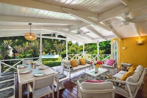 The large deck with tropical wood flooring overlooking the garden and pool