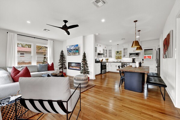 The living room, kitchen, and dining area with an open concept are bathed in abundant natural light.