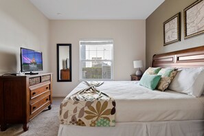Spacious king-size bedroom with tv for entertainment and a private bathroom.