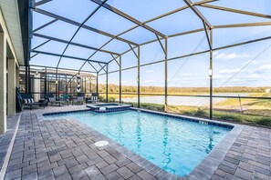 Relax here on our glass-enclosed patio where your view is of a lake framed by trees. With chaise loungers, a swimming pool and hot tub, this space feels like a peaceful resort.