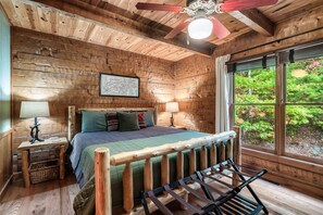 Cozy up in this serene bedroom with rustic charm and large windows that bring the beauty of the outdoors right to your bedside.