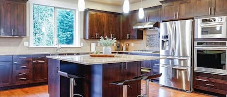 With rich wood paneling, stainless steel appliances, and sleek granite countertops, this kitchen is a chef's dream