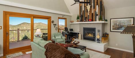 Living room with amazing views, ceiling fan, fireplace, western decor