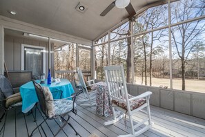 Take in mother nature and all of it's beauty in this screened in porch | Rocking Chairs | Outdoor Dining Table