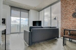 Pristine living room enriched with an abundance of natural light from floor to ceiling window!