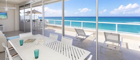 All photos are recent as of January 2023. Screened patio with open-air balcony providing elevated ocean views. The patio comes furnished with a dining table plus a lounge with television. 