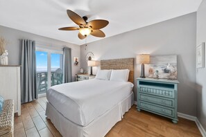 The plush king size mattress beckons with the promise of a restful night's sleep under the gentle breeze of the ceiling fan.