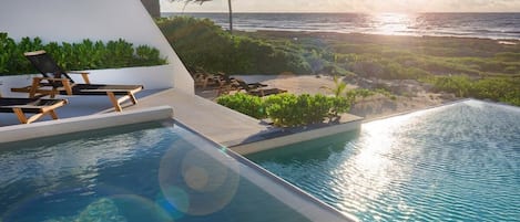 Impressive pool with a view of the sea. Comfortable sun loungers are located alongside.