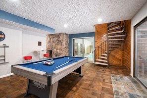 Game room with access to pool and spiral staircase to the kitchen
