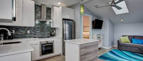 Kitchen island, stainless steel appliances, open floor plan, ceiling fan