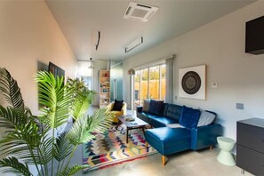 Comfortable living room with locally produced glass mosaic art and 65" HDTV. 