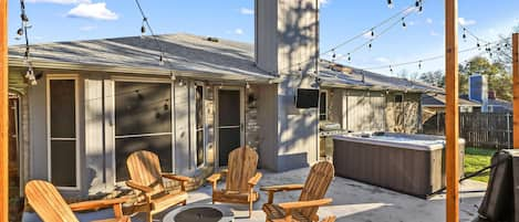 Backyard Patio with Propane Fire Pit Lounge Chairs, Hot Tub, and Grill