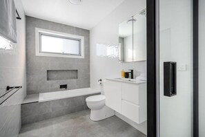 Main bathroom with separate tub, and shower . As well as a toilet and vanity.