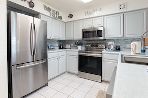 Fully stocked kitchen with stainless steel appliances.