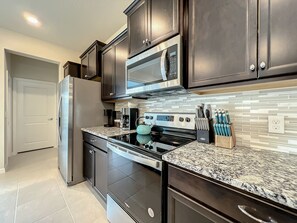 - Stainless steel appliances & granite counters make cooking feel like a breeze
- Stocked with a coffee maker, knife block, & all the essentials for easy meal prep
- Modern backsplash & rich cabinetry bring both style & function to your kitchen experience

