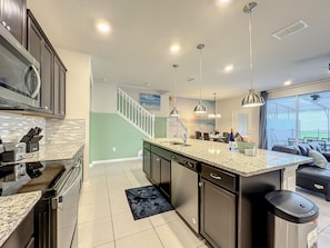 Open-concept kitchen with a view into the living area—ideal for cooking while staying connected with your group.