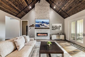 Welcome to the heart of the home - an open concept living room designed for gathering and relaxation. With an 85-inch TV and plenty of comfortable seating for the entire group, this space is p