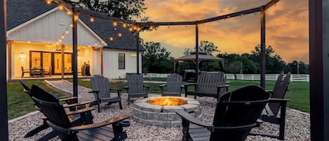 Enjoy the outdoors in this stunning fire pit area. With seating for 12, there's plenty of space to relax and enjoy the fire. At night the lights illuminate the countryside, providing a picturesque backdrop for unforgettable evenings under the stars.