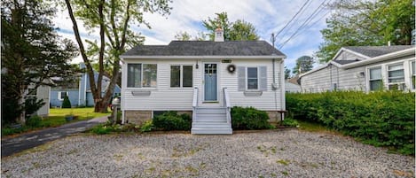 Front of house with parking space for two cars on the gravel drive