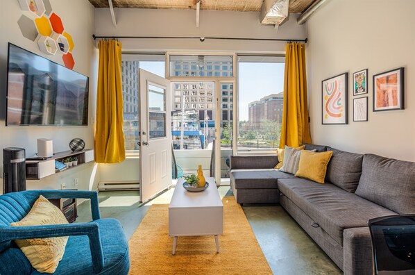Bright and open living room with vibrant modern decor, featuring a sofa bed for an extra guest or couple
