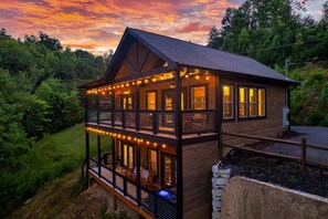 Expansive upper and lower decks with lights provide plenty of spaces to enjoy the outdoors, day or night