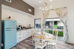 Kitchenette has a sliding door that opens to the shared backyard with BBQ grill.