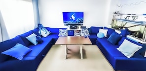 Lounge area with electronic coffee/dining table, television, gaming console +