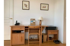 Bureau , téléphone , une imprimante et sa chaise dans la chambre.