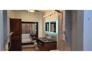 Double vanity with plenty of storage, makeup mirror and bathrobes.