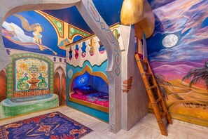 Step into a magical world with this enchanting theme room, featuring vibrant murals and a cozy bunk bed for an unforgettable stay.