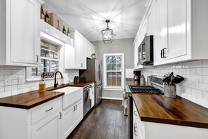 The farmhouse-style kitchen, with its gleaming stainless steel appliances and warm butcher block countertops, seamlessly blended rustic charm with modern convenience.