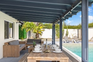 Refreshing Outdoor dining table in Noord Aruba - Alfresco elegance awaits under the open sky - Elevate your dining experience amidst the beauty of nature - Stunning pool views