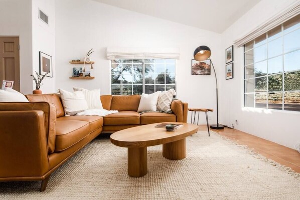 Cozy leather sofa and coffee table, framed photos of nearby favorite landmarks, and big windows that let in lots of light!